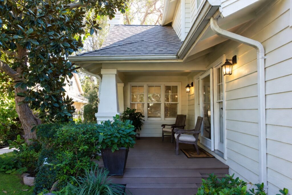 Welcoming front porch styled with chairs potted plant and warm lighting