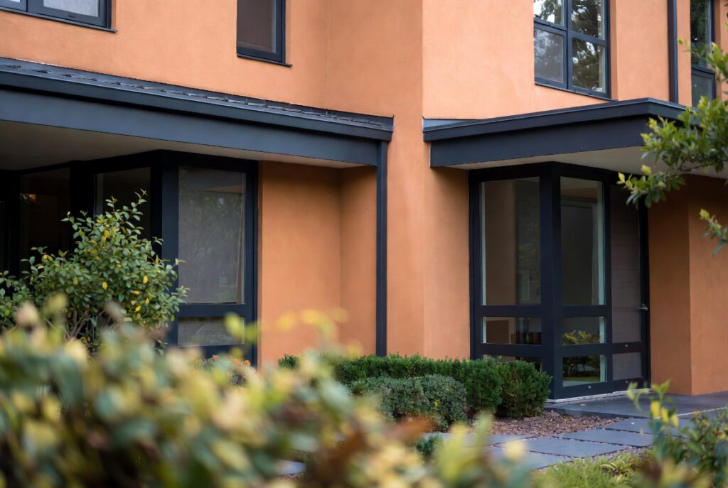 Home exterior in warm earthy clay color with charcoal trim modern palette