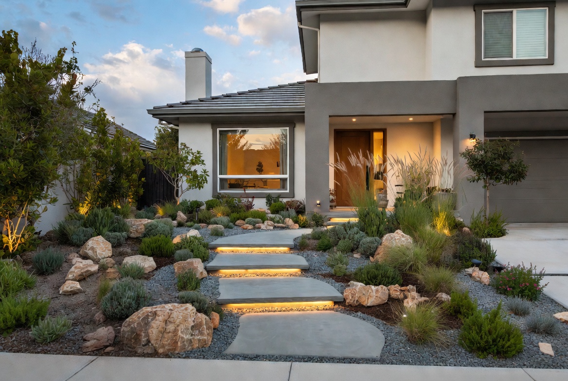 Architectural front yard landscaping with layered textures, natural stone pathway and warm smart lighting