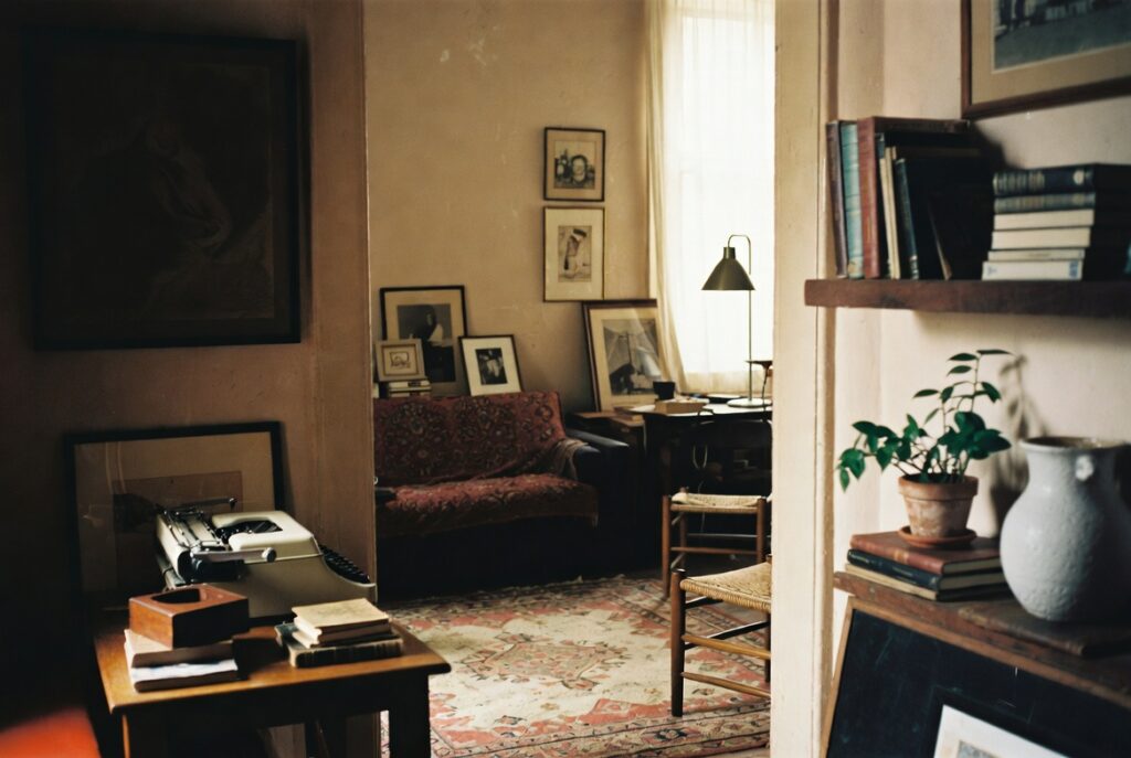 Layered collected living room with vintage finds, textured textiles and personal objects, warm light, candid shot