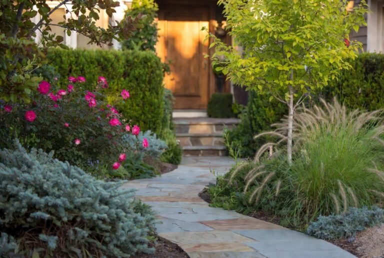Stunning front yard landscaping with stone path layered plants and warm evening light