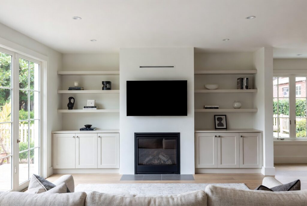 "Add built-in storage around fireplace in small living room - Custom shelves and cabinets integrated beside and above fireplace creating organized spacious and functional modern interior"