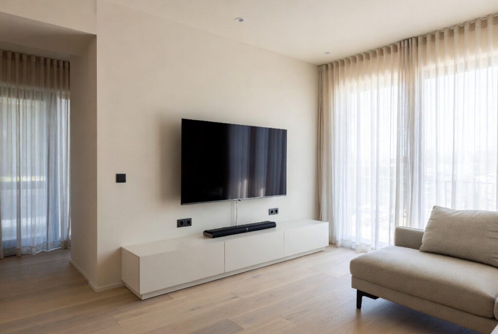 "Mount TV on the wall to save space in small living room - Wall mounted flat screen TV creating clean open and spacious modern interior with more floor area"
