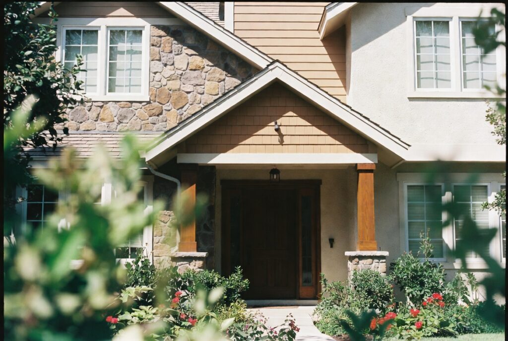 Home exterior mixing siding stone veneer and wood accents for layered curb appeal