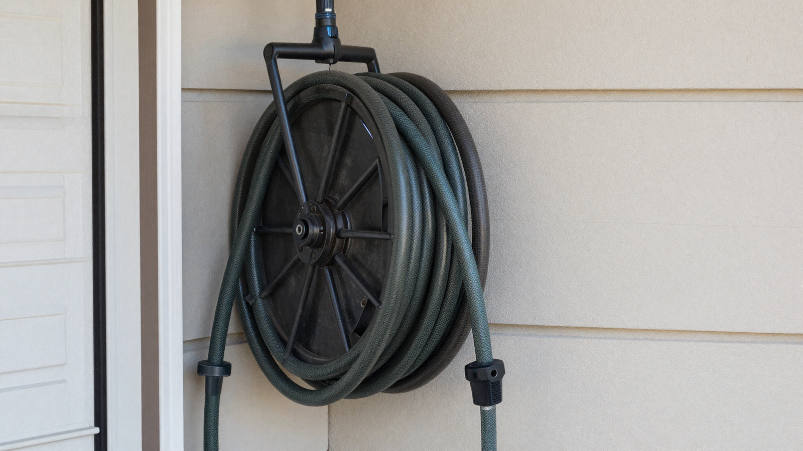 Extension cord and garden hose reel mounted neatly on garage wall