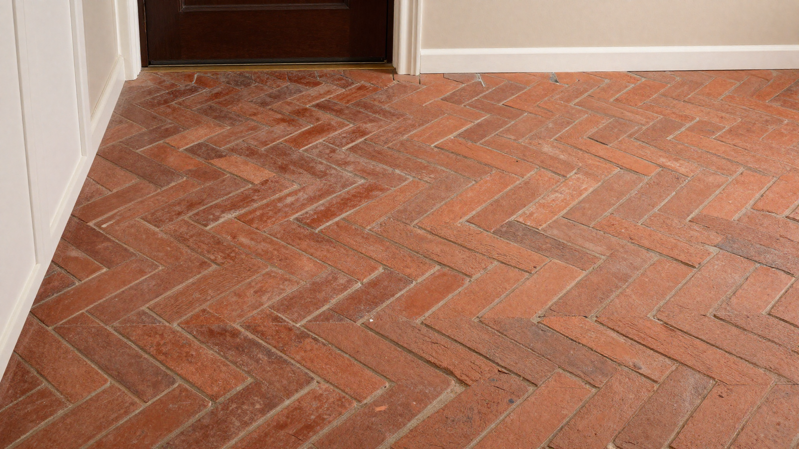 Mudroom entryway floor with herringbone brick pavers in warm terracotta red tone