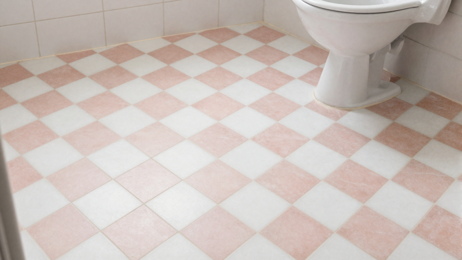 Bathroom floor with vintage checkerboard tile in soft blush pink and white