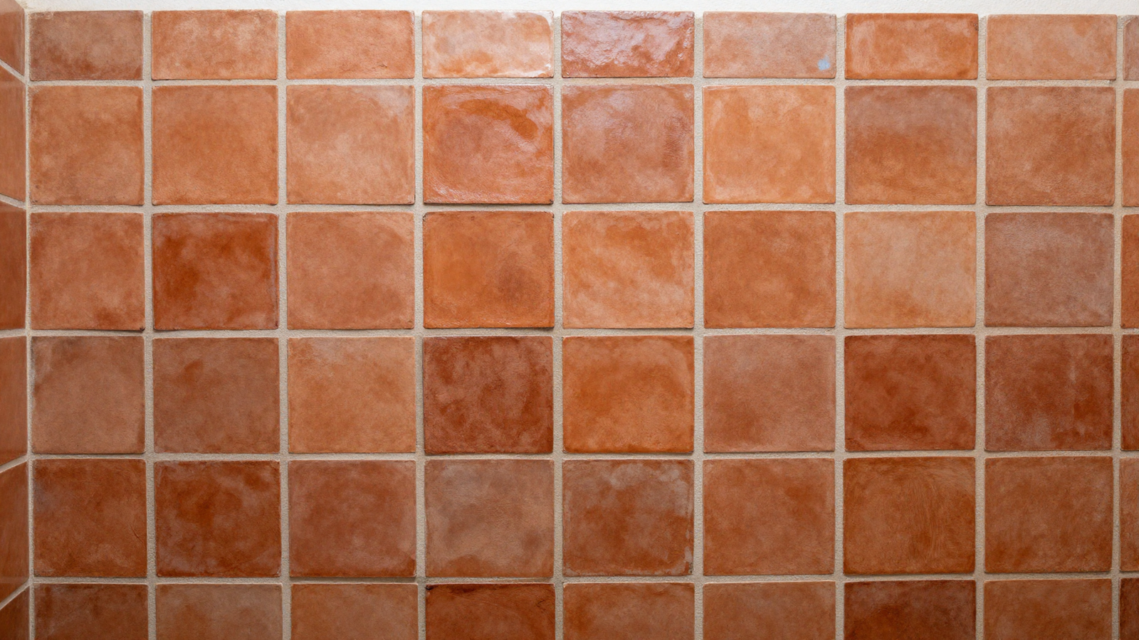 Bathroom shower wall with handmade zellige tile in warm terracotta and subtle glaze variation