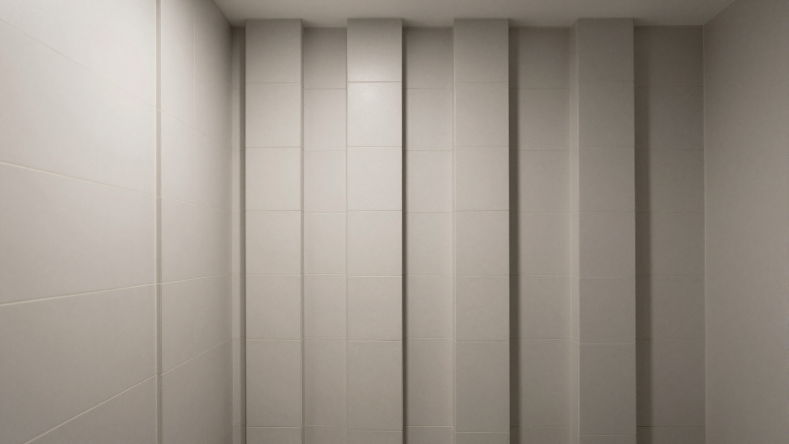 Narrow bathroom with vertically stacked rectangular tile columns drawing the eye upward
