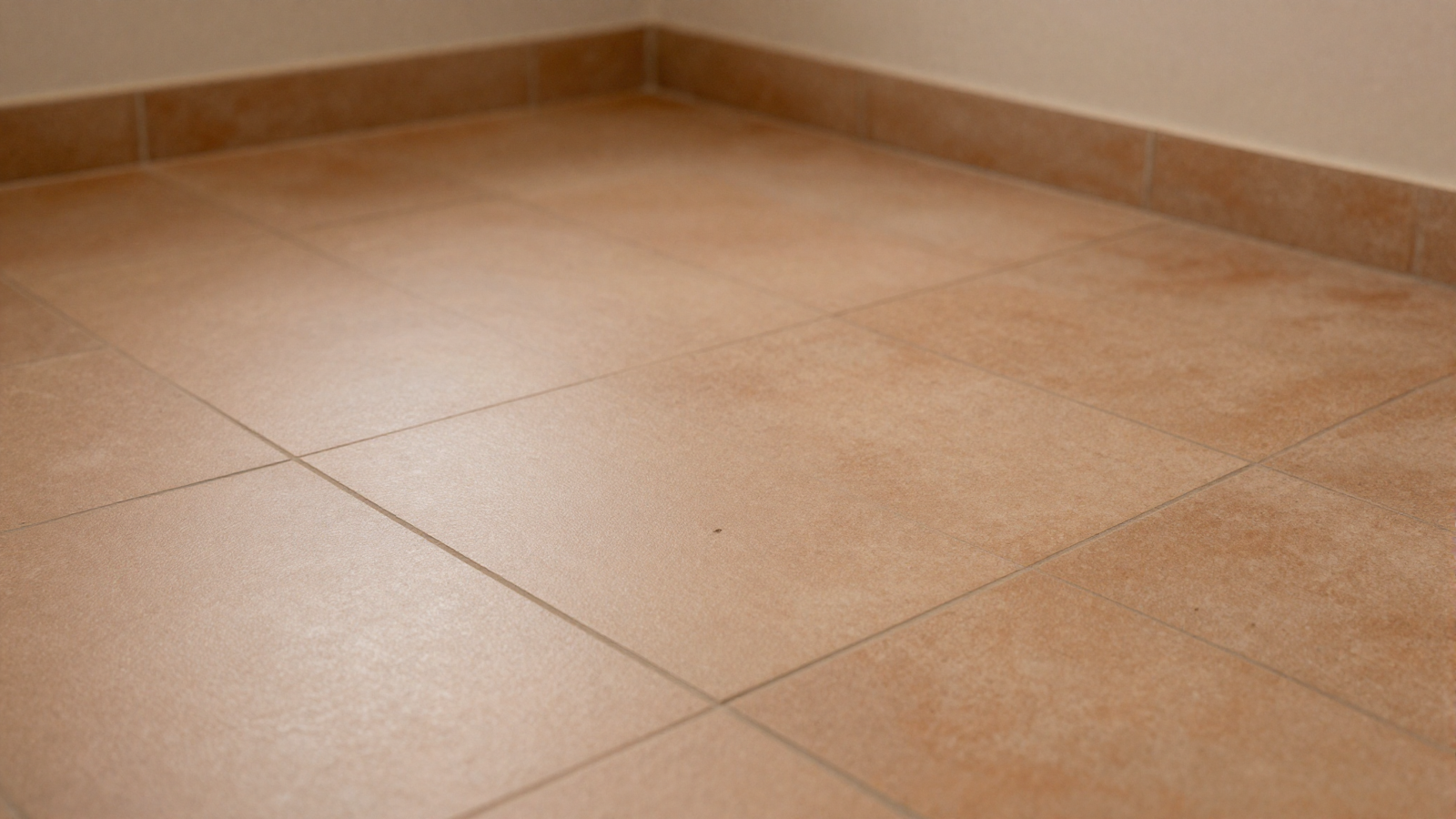 Bathroom floor with warm muted terracotta square tile in soft earthy tone