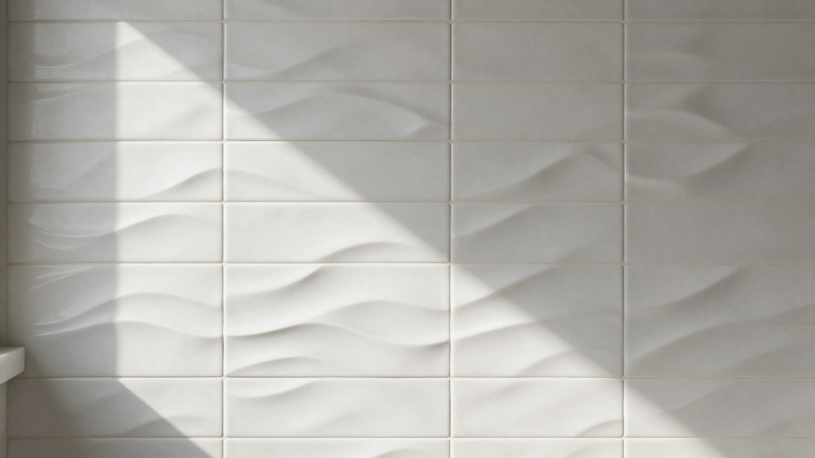 Bathroom feature wall with sculptural wave-relief tile in soft white catching natural light