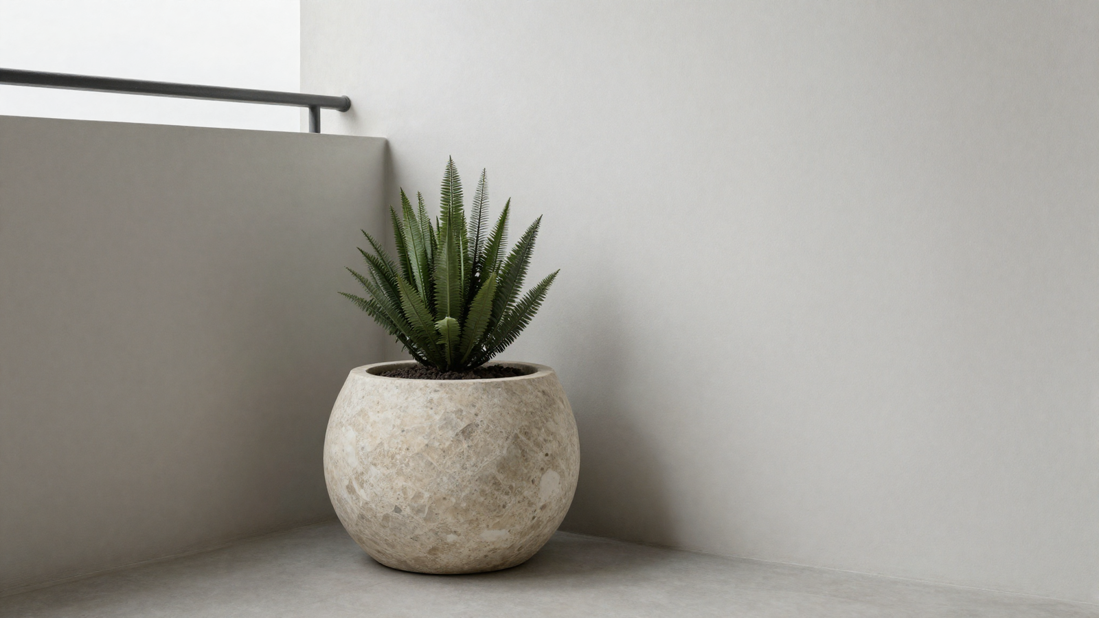 Minimalist balcony corner with sculptural stone planter and single architectural plant
