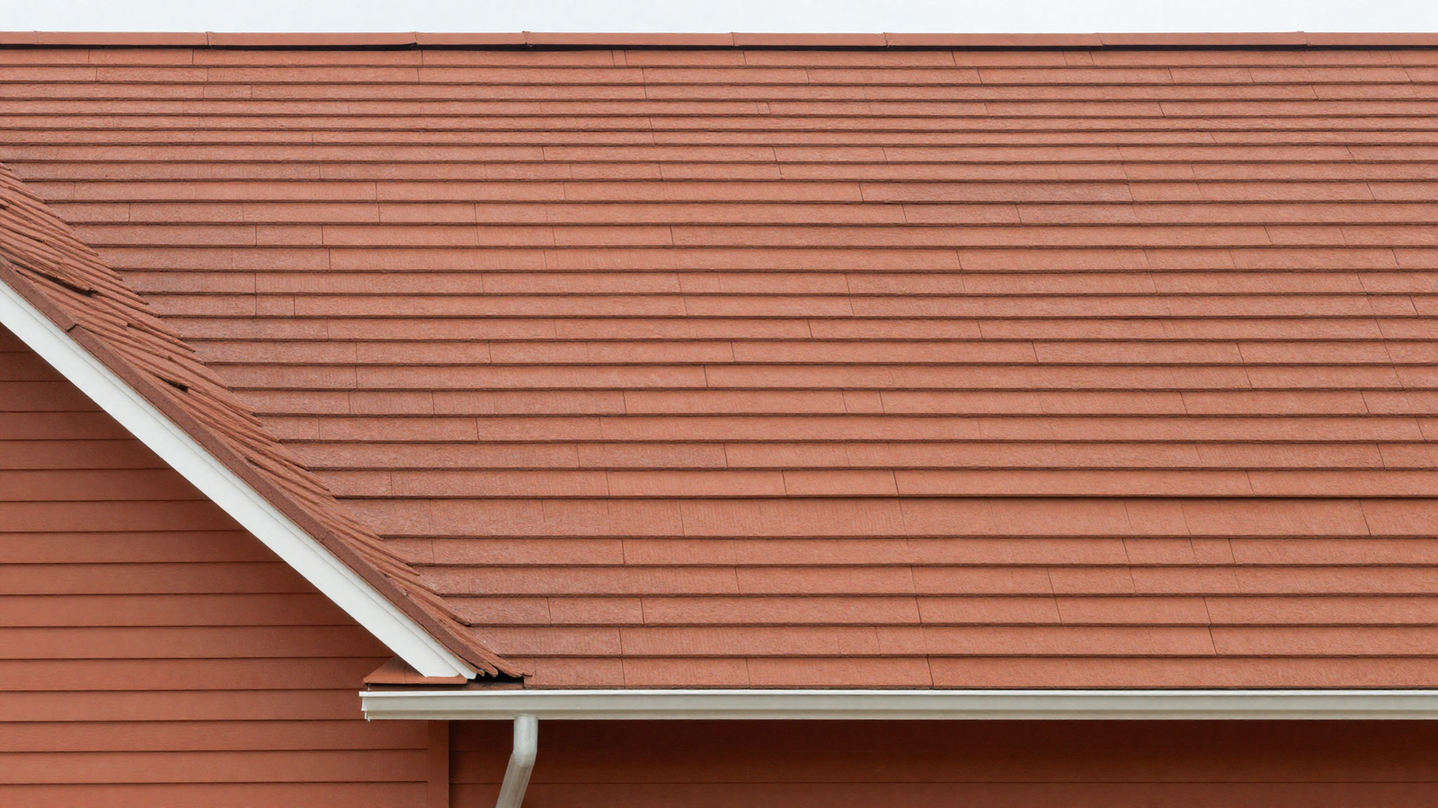Roofline of a house in an earthy warm terracotta tone complementing the siding color below