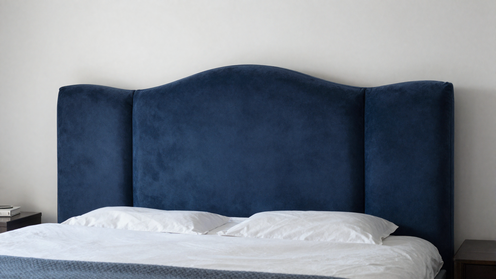 Bedroom with curved wavy velvet headboard in deep navy blue with sculptural undulating lines