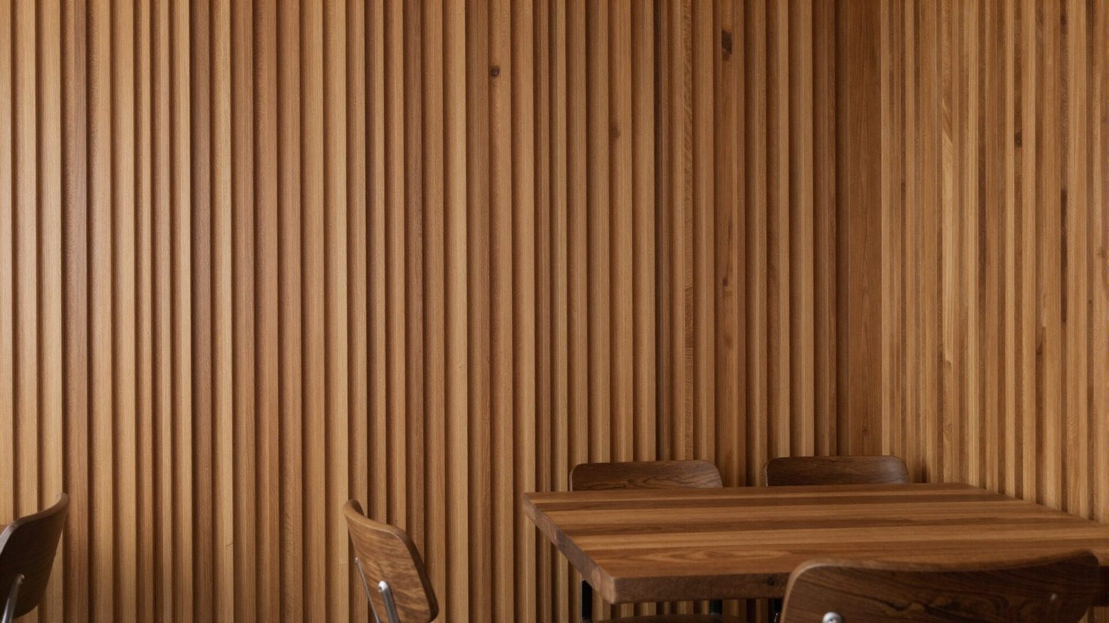 Dining room with warm wood-clad wall paneling in vertical slats