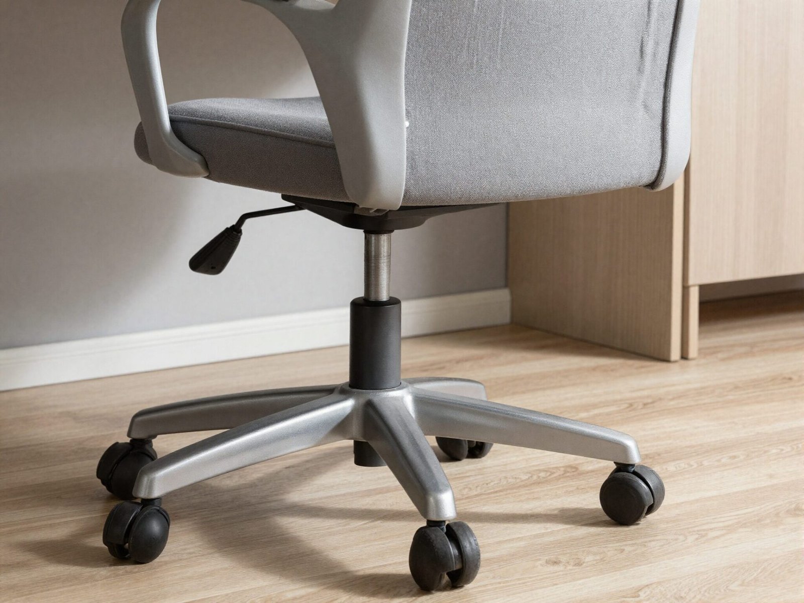 Feet resting on an adjustable footrest beneath a desk chair