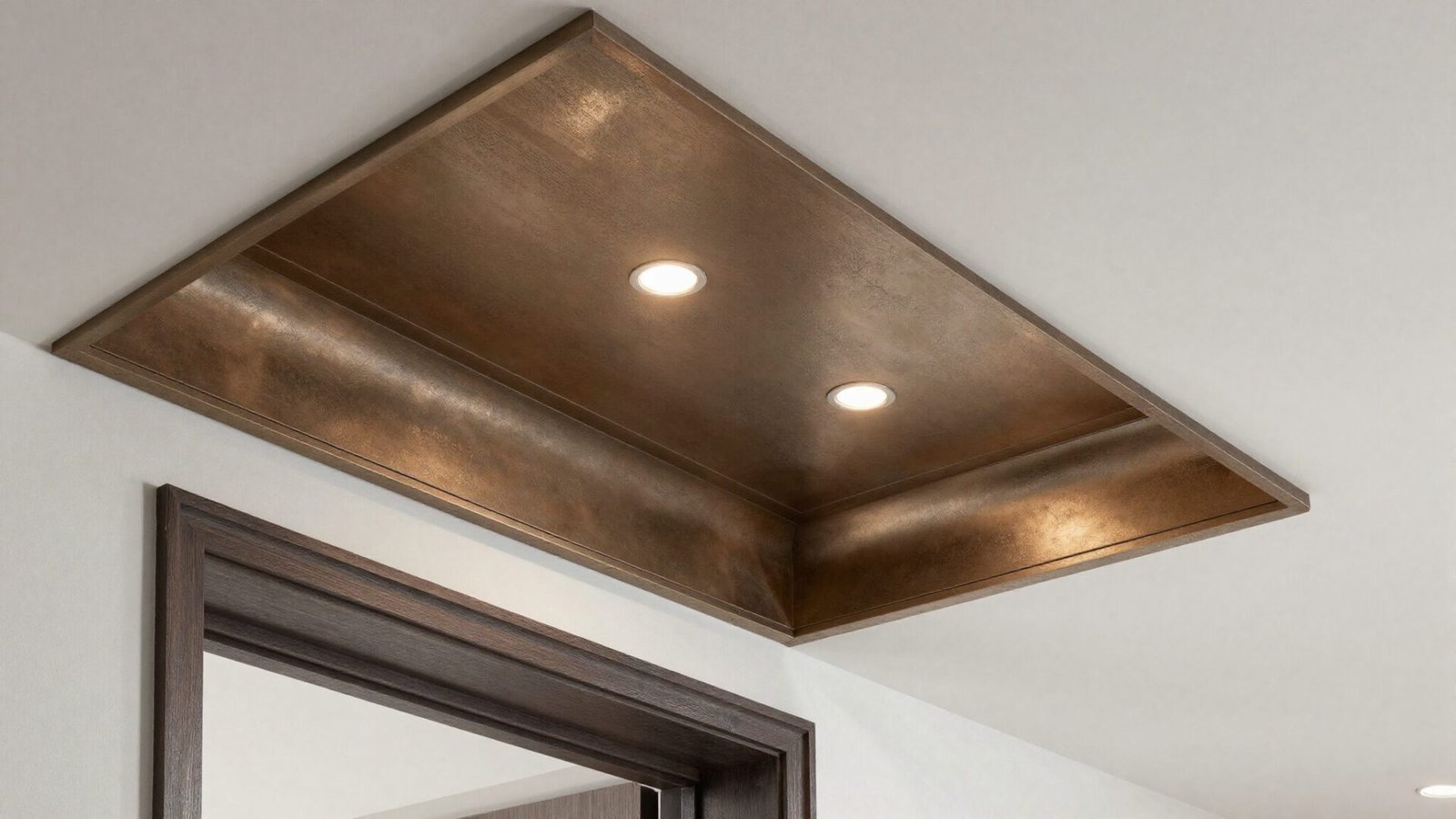 Entryway ceiling with a metallic bronze finish accent panel catching light