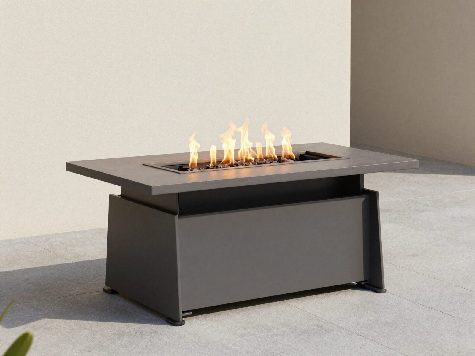 Modern gas fire pit table positioned near a house patio wall