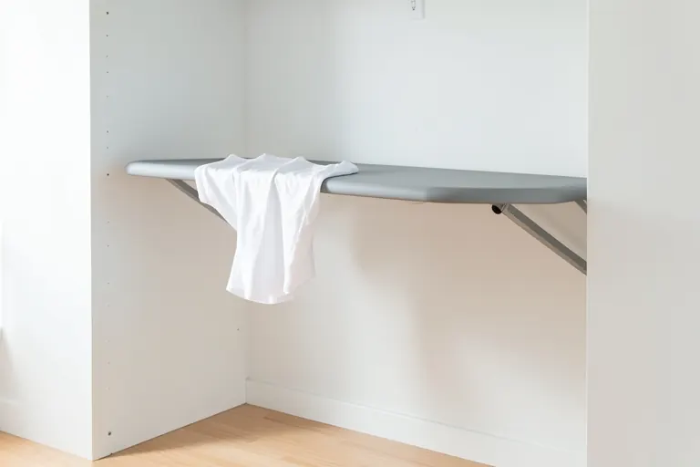 A closet rod with sections of shirts organized by color, each section marked with a small colored tag.