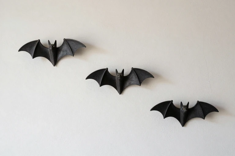 Sparse blackened metal bats mounted on textured plaster