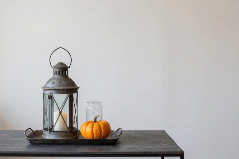 A distressed metal lantern holding a candle on a coffee table.