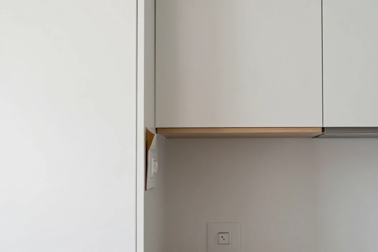 A narrow kitchen shelf being planned with a blank paper template