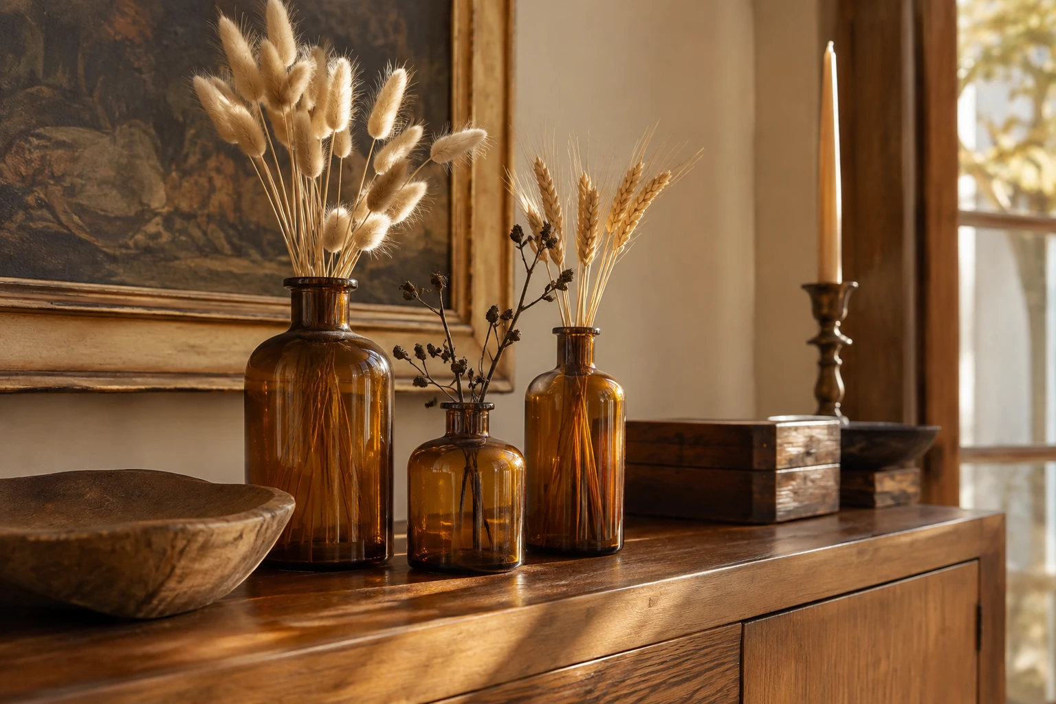 Amber glass bottles with dried autumn florals on a table